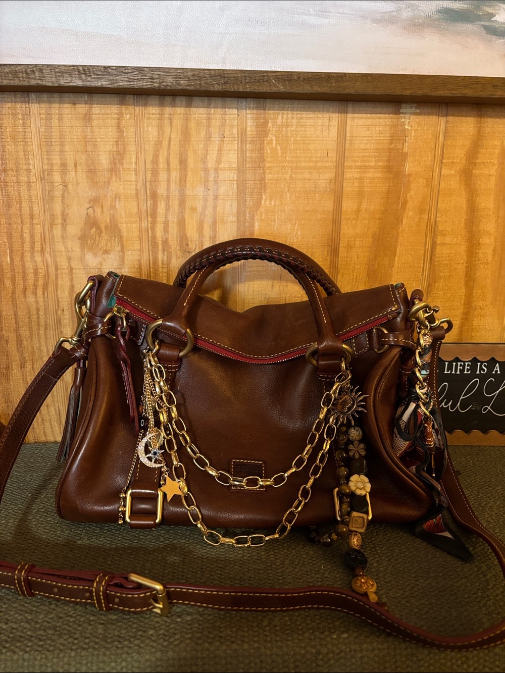 Dooney & Bourke Brown Leather Handbag with Chains & charm accents.